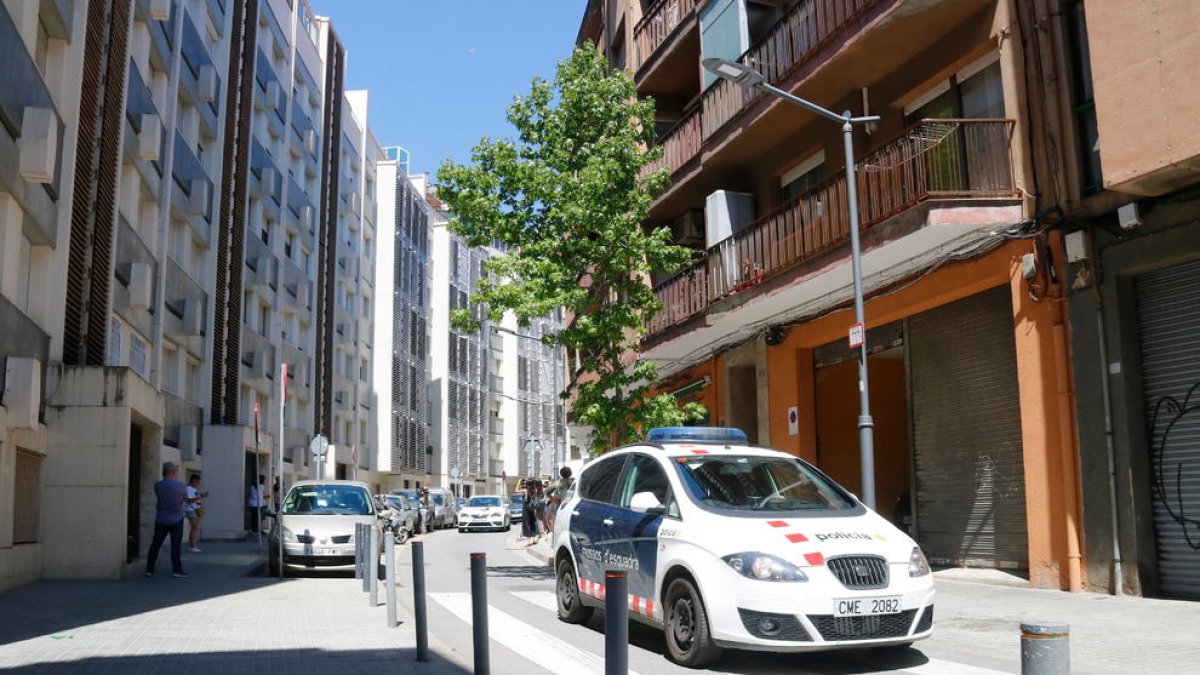 Un vehicle dels Mossos d'Esquadra davant l'edifici del carrer Burriac del barri de Cerdanyola de Mataró, on va aparèixer morta la nena de 13 anys.