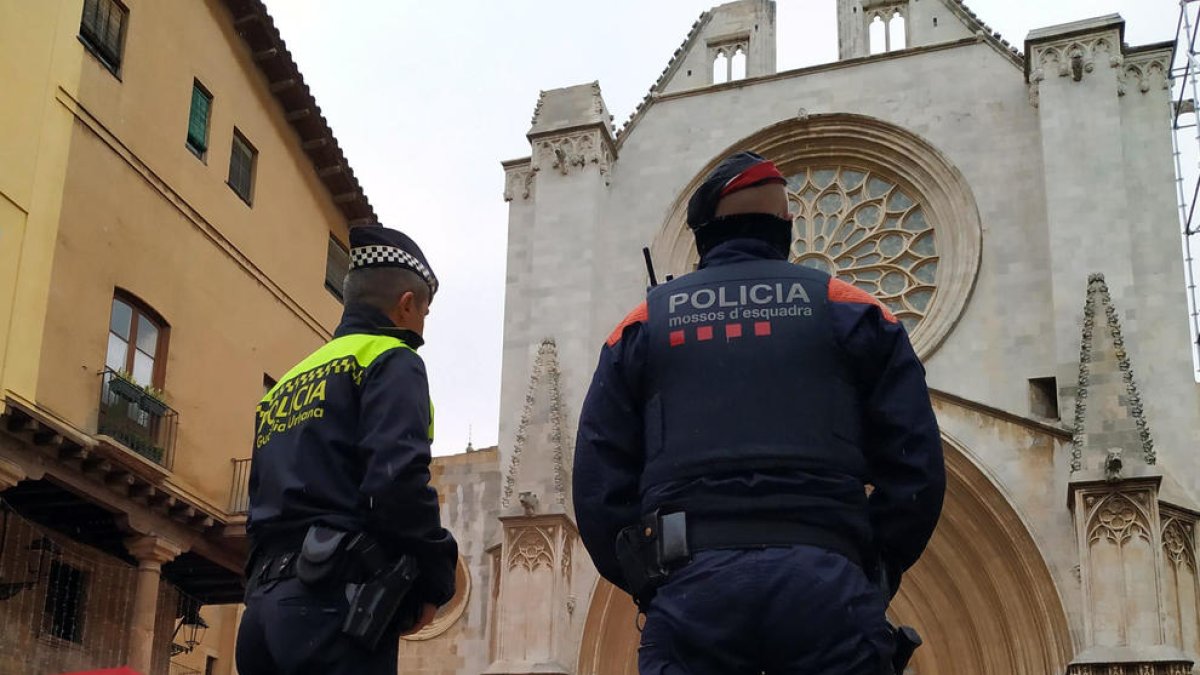 Dos agentes, uno de Mossos y uno de Guardia Urbana, delante de la Catedral.