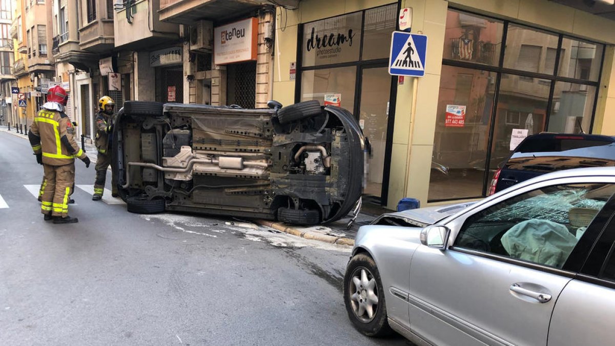 Plano general de los vehículos accidentados, uno de ellos volcados después del choque.