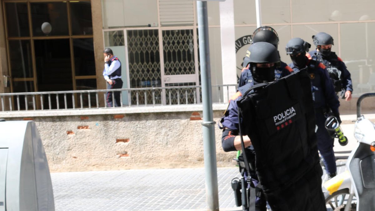 Agentes ARRO de los Mossos d'Esquadra saliendo del portal de un bloque de pisos de Valls.