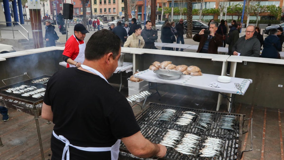 Varios cocineros preparan la sardinada popular organizada por la Liga Contra el Cáncer.