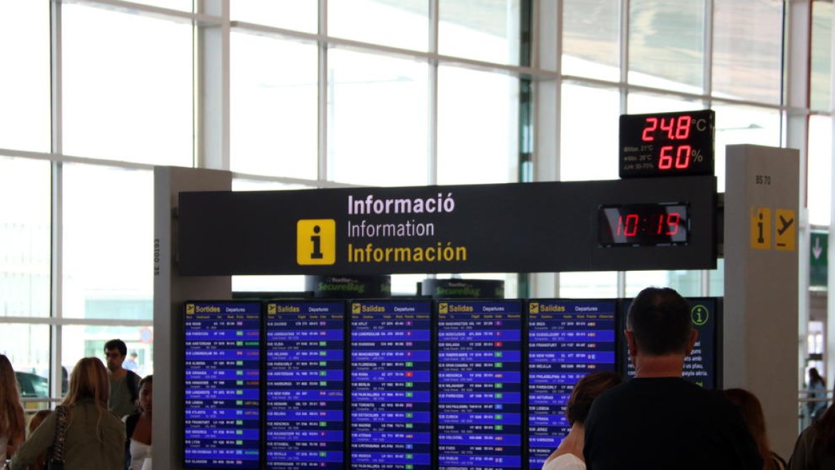 Pla mitjà d'un panell informatiu de vols de sortida a l'aeroport del Prat, amb cap vol cancel·lat.