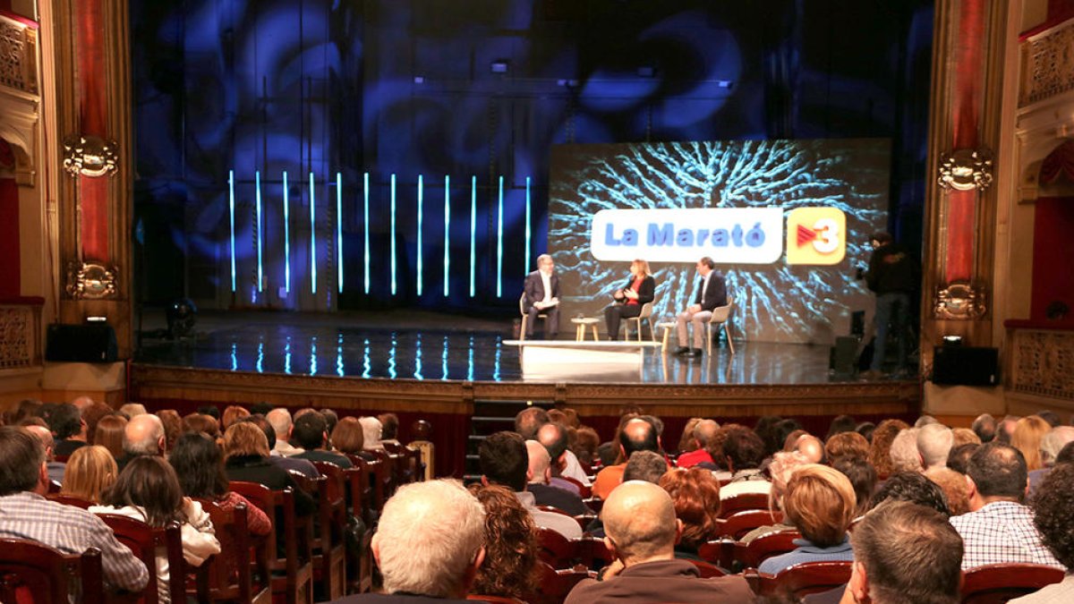 Imatge del presentador Josep Cuní; de l'Eva Ballvé, un dels testimonis de la Marató; i del doctor Antoni Riera de l'Hospital de Bellbitge, durant el programa al Teatre Fortuny a Reus.