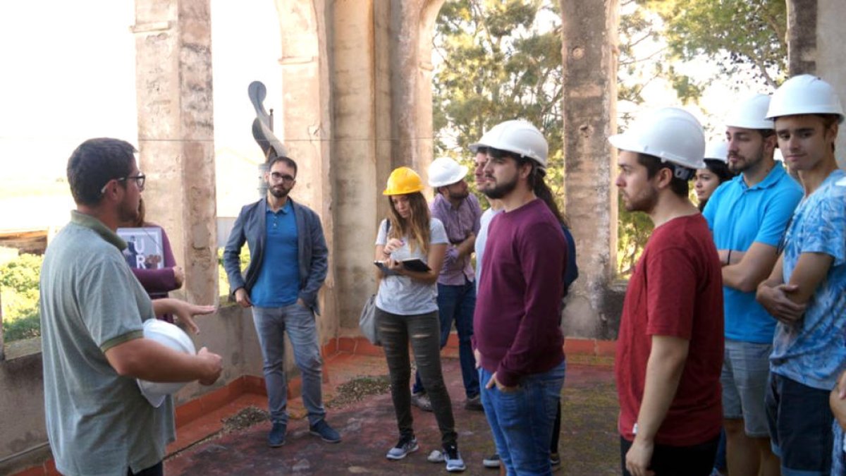 Plano general de algunos estudiantes de arquitectura de la URV analizando una masía en l'Aldea.