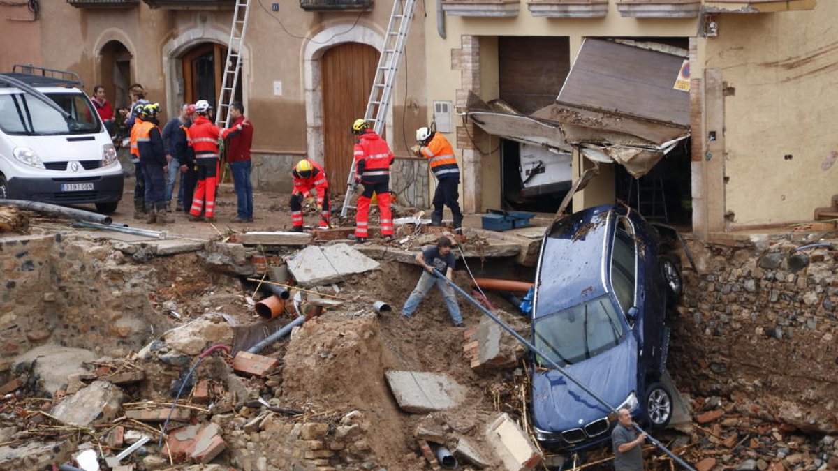 Imagen de efectivos trabajando para retirar un coche arrastrado por la riada durante el temporal a Montblanc