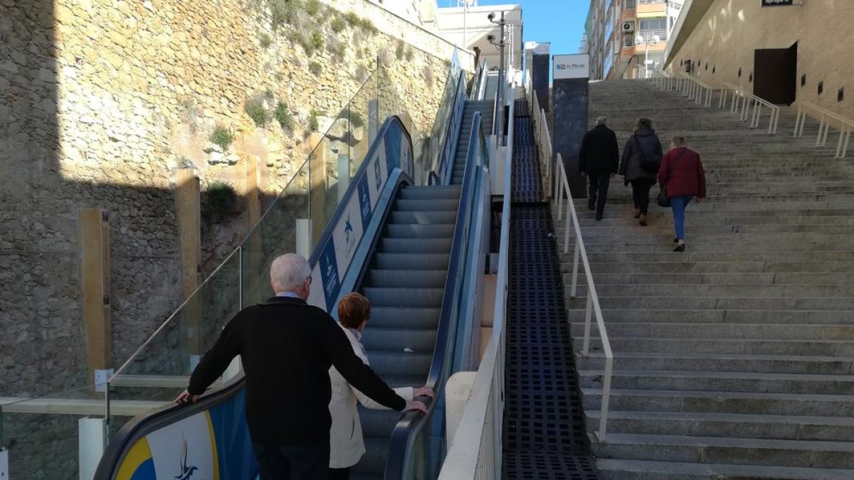 Dos personas dudan si subir por las escaleras estropeadas y otros tres hacen el tramo afectado a pie.