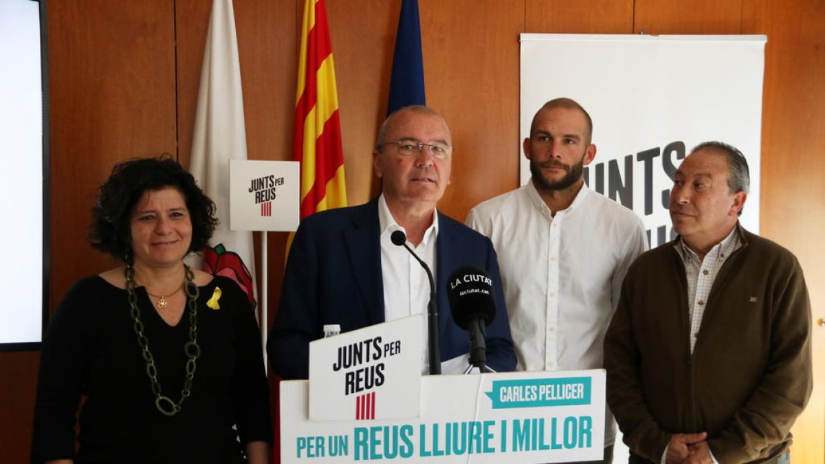 El cap de llista de Junts per Reus, Carles Pellicer, acompanyat de membres del partit en la roda de premsa per valorar pactes postelectorials.