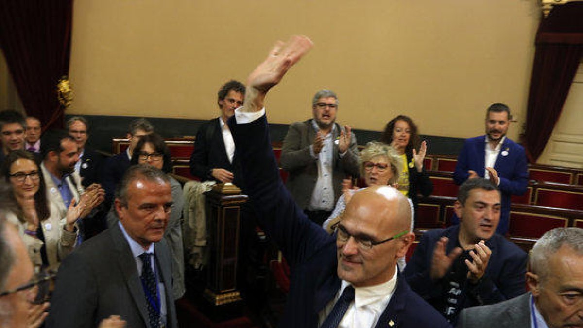 Plano frontal del senador de ERC Raül Romeva que saluda con la mano durante la sesión de constitución de la cámara alta, en Madrid el 21 de mayo.