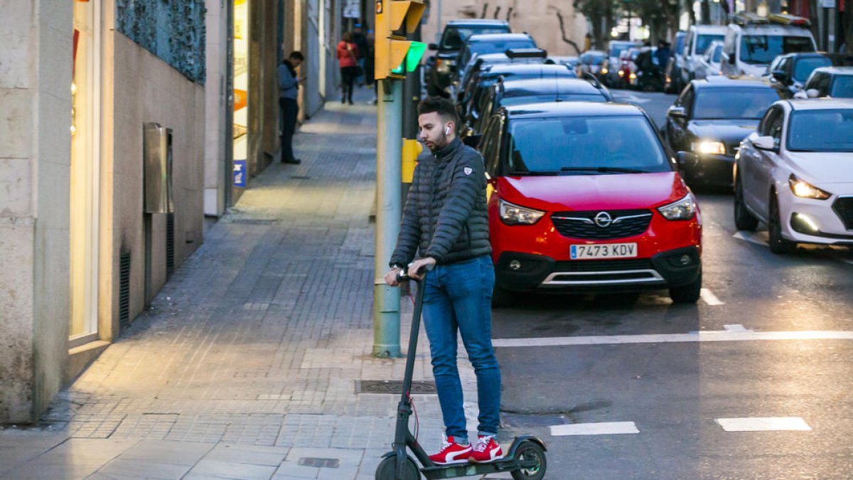 Un chico circula en patinete eléctrico por el centro de Tarragona.