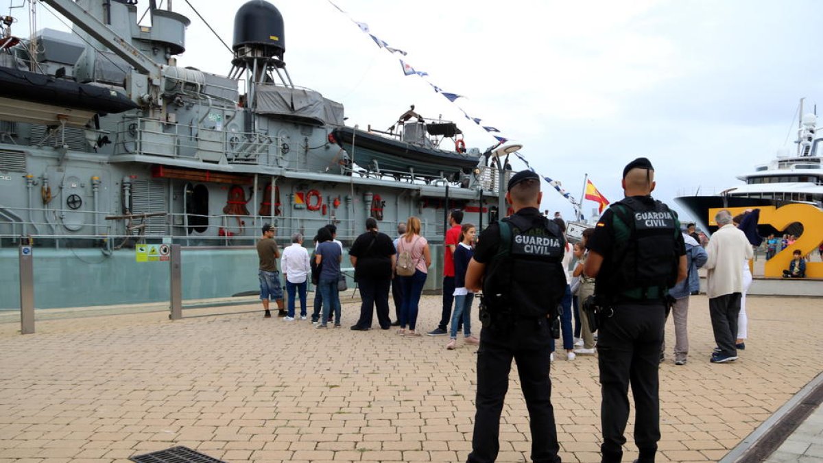 Pla general de dos agents de la Guàrdia Civil d'esquenes fent tasques de vigilància del patruller Infanta Cristina ubicat al Moll de la Costa del Port de Tarragona.