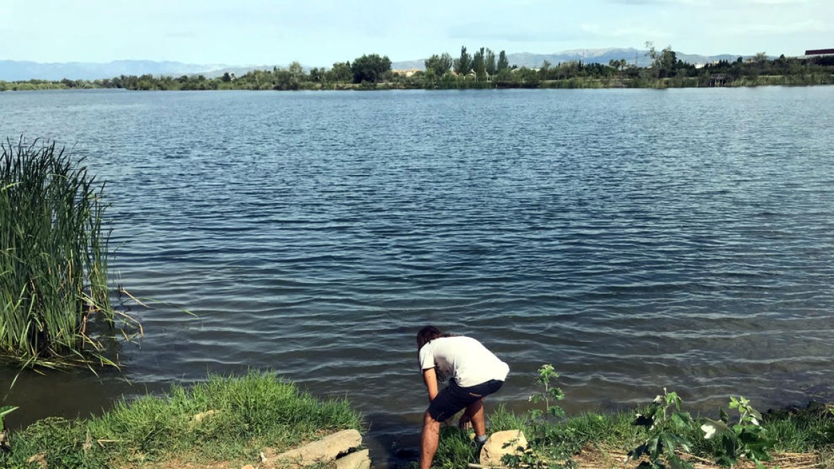 L'artista Òscar de la Fuente buscant una pedra al riu Ebre per convertir-la en altaveu de la sonoritat de l'entorn.