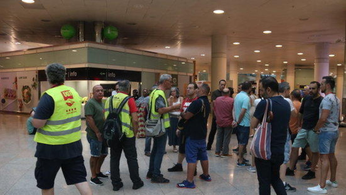 La quincena de trabajadores de Iberia concentrados en la zona de llegadas del aeropuerto del Prat.