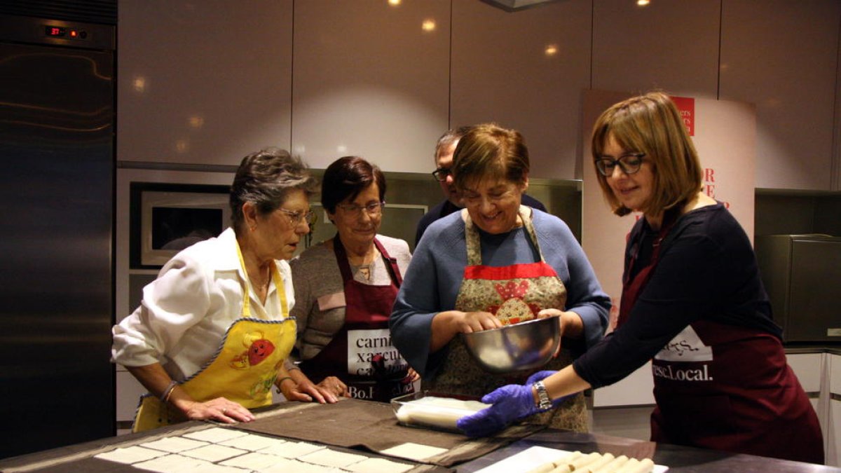 Un grup de dones cuinant canelons.