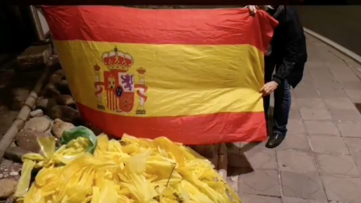 Miembros del grupo muestran la montaña de lazos retirados junto con una bandera española.
