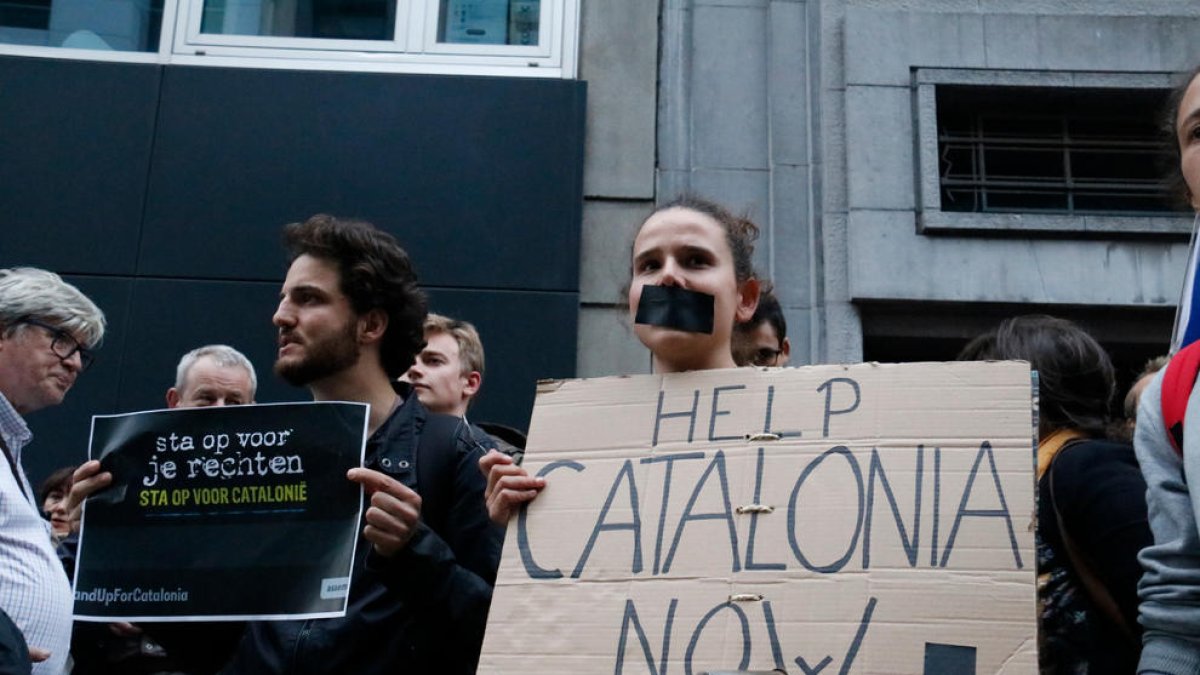 Una noia amb el cartell 'Help Catalonia now' durant la protesta davant l'ambaixada espanyola a Brussel·les.
