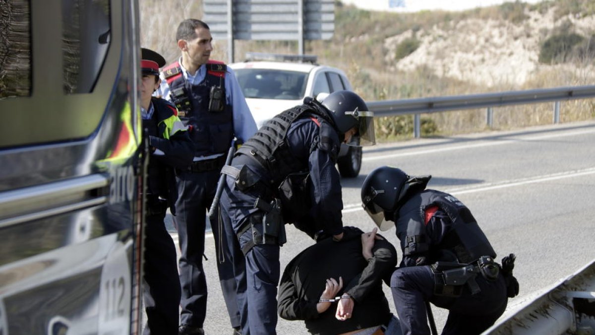 Pla obert del noi detingut pels Mossos d'Esquadra, d'esquenes i emmanillat, a les proximitats del peatge de l'AP-7 a Tarragona. Imatge del 21 de febrer del 2019