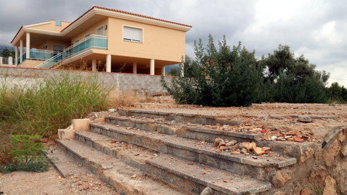 Las escaleras que se salvaron de la explosión y el solar cubierto con cemento que quedó donde había el chalet de los terroristas del 17-A, con la casa de los vecinos más próxima reformada al fondo.