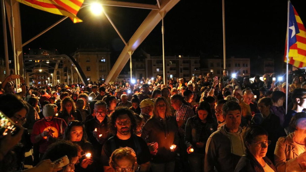 Plano picado de una parte del puente del Estado de Tortosa llena de gente con velas durante al concentración en recuerdo de los presos.