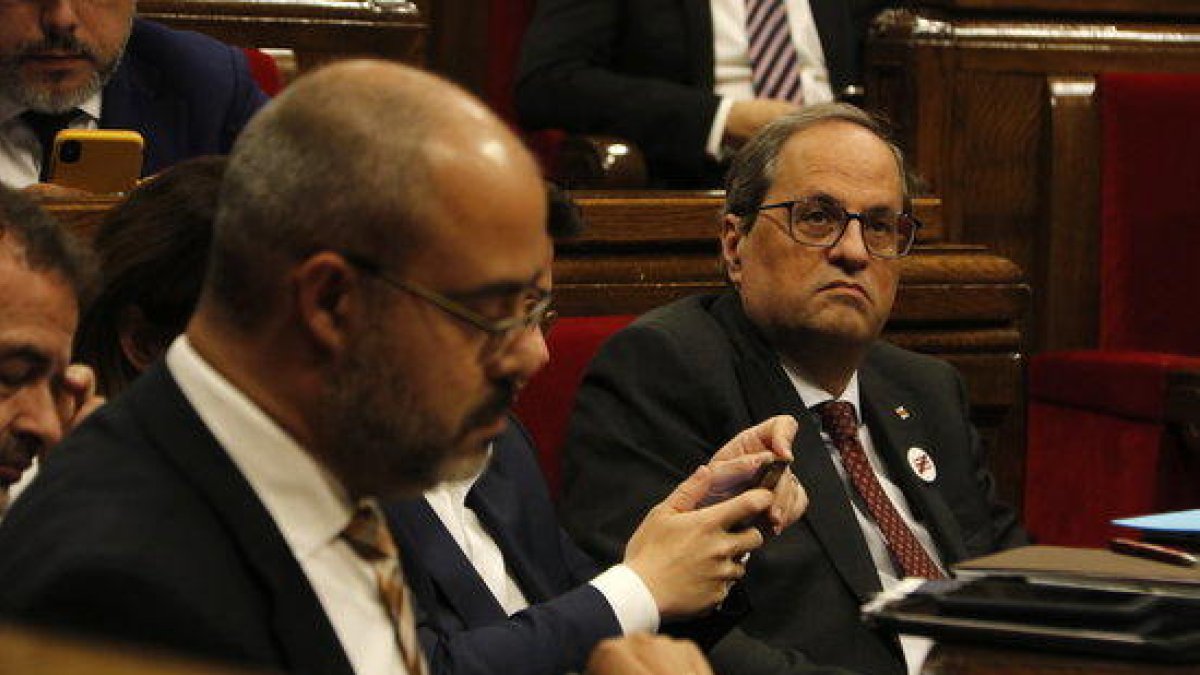 El presidente del Govern, Quim Torra, en el Parlament. En primer plano, desenfocado, el conseller de Interior Buch.