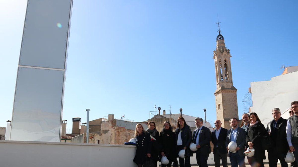 Foto de família al terrat del Museu Casteller de Catalunya a Valls, en una visita d'obres amb la consellera de Cultura, Laura Borràs, amb el campanar de la ciutat al fons.