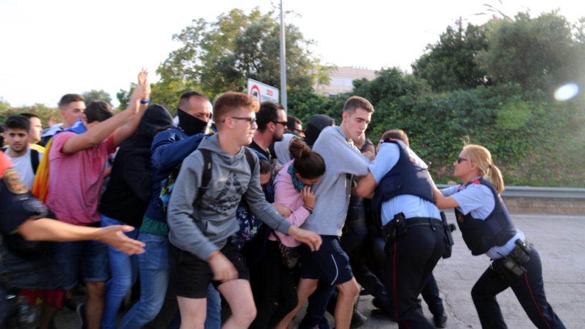 Agentes de los Mossos bloquean el grupo de manifestantes que intentaban acceder a la autopista AP-7 en l'Ampolla por el peaje.