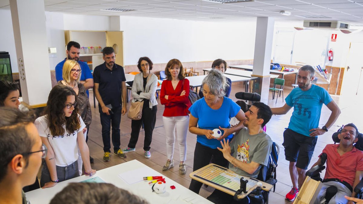 Dos chicos de la Associació 'La Muntanyeta' sonríen después de recibir los proyectos de los estudiantes.