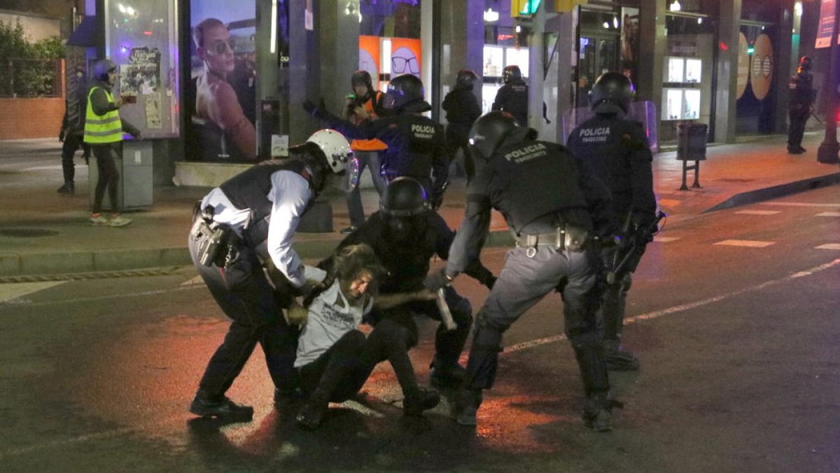 Plano general de los Mossos d'Esquadra deteniendo a un manifestante durante la cuarta noche de disturbios en Tarragona.