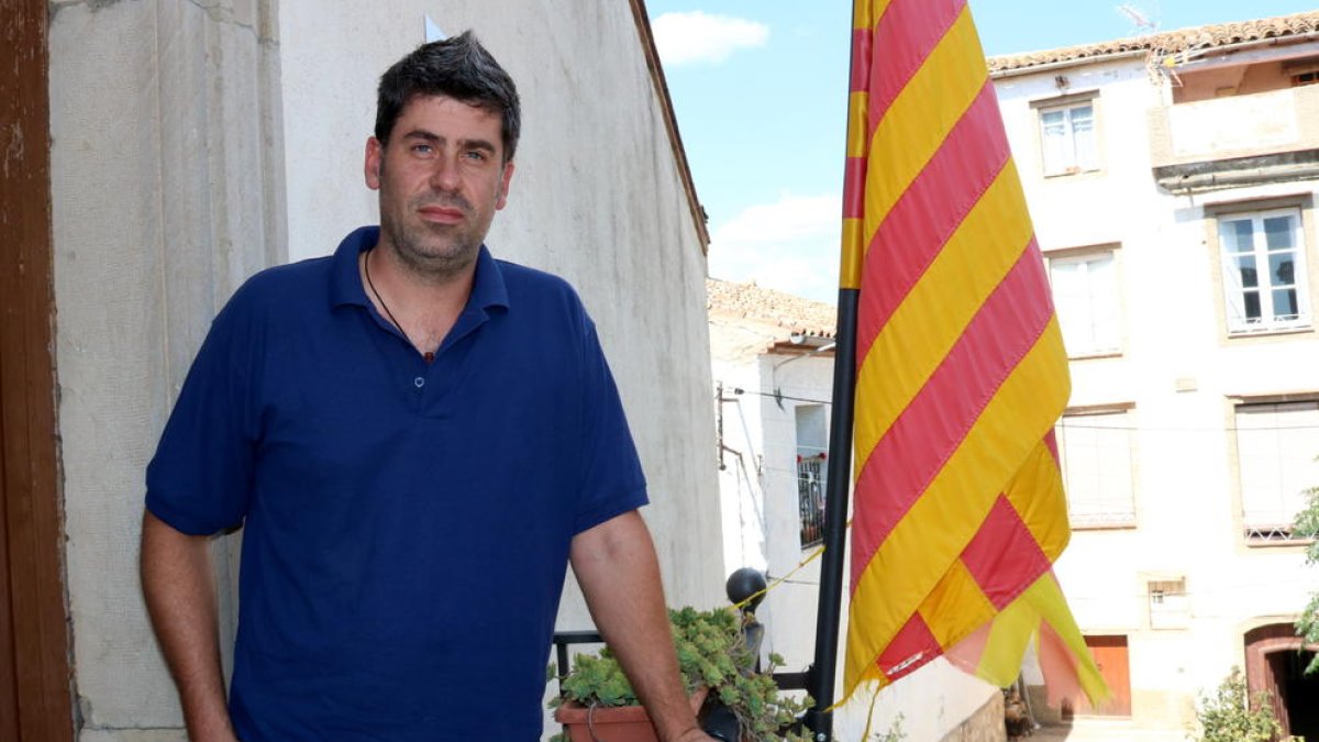 Xavier Gràcia, alcalde de Gratallops, al balcó de l'ajuntament amb la senyera al costat.