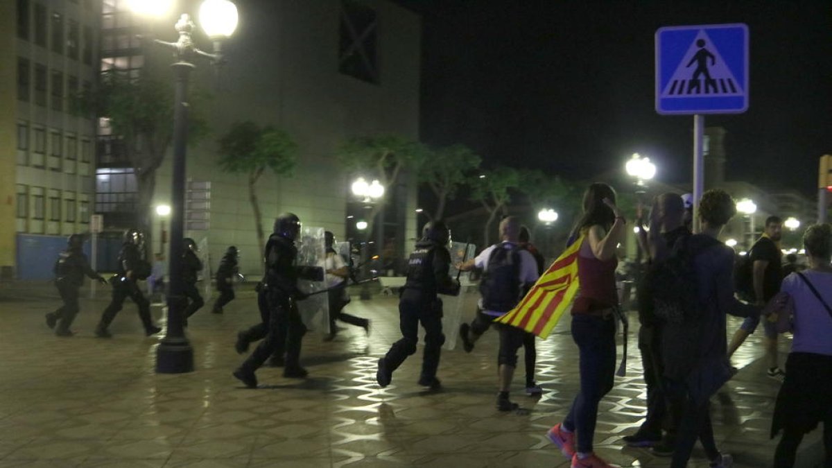 Plan|Plano general de agentes de la Policía Nacional al inicio de las cargas policiales en la cuarta noche de disturbios en Tarragona. Imagen del 19 de octubre del 2019 (Horizontal).