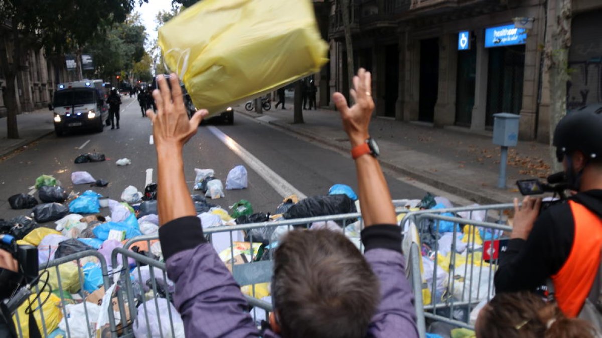 Un hombre lanza una bolsa de basura en torno a la delegación del gobierno español en Barcelona.