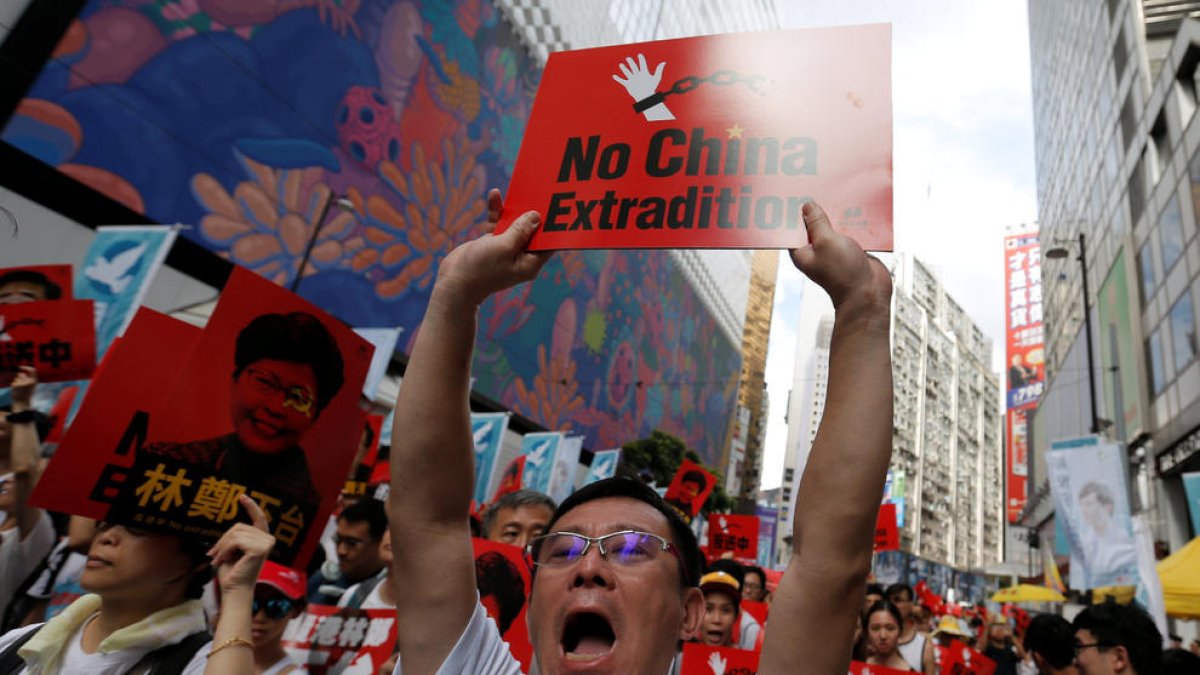 Un hombre sosteniendo un cartel donde se puede leer en inglés «No China Extradition», en la manifestación en Hong Kong en contra de la ley de extradición.