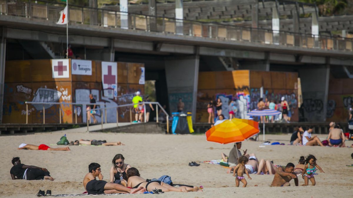 Desenes de banyistes gaudien ahir d'un dia de platja a Tarragona.