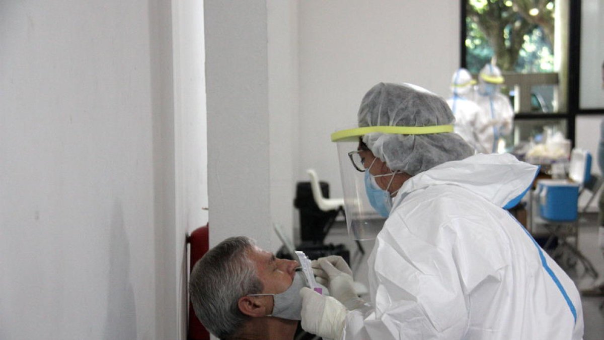 Una persona i un professional sanitari mentre fan una PCR en el marc del cribratge massiu de la Seu d'Urgell.