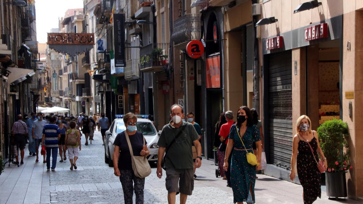 La calle Monterols de Reus con varias personas caminando con mascarilla.