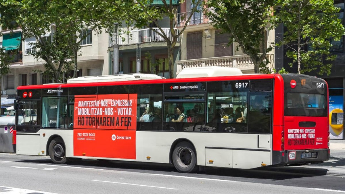 Plano general de un autobús de TMB con el anuncio de Òmnium Cultural.