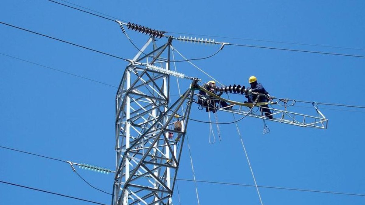 Dos operarios reparan una línea de alta tensión de Endesa /