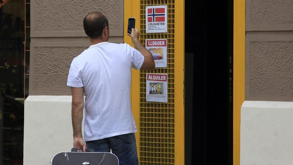 Un turista se interesa por un apartamento turístico en el barrio de La Barceloneta.