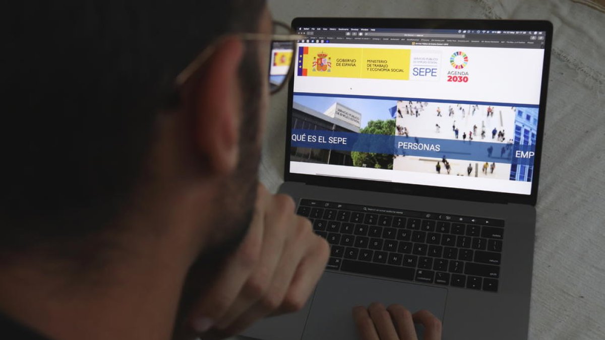 Un home mirant la pàgina web del Servei Estatal Públic d'Ocupació (SEPE).