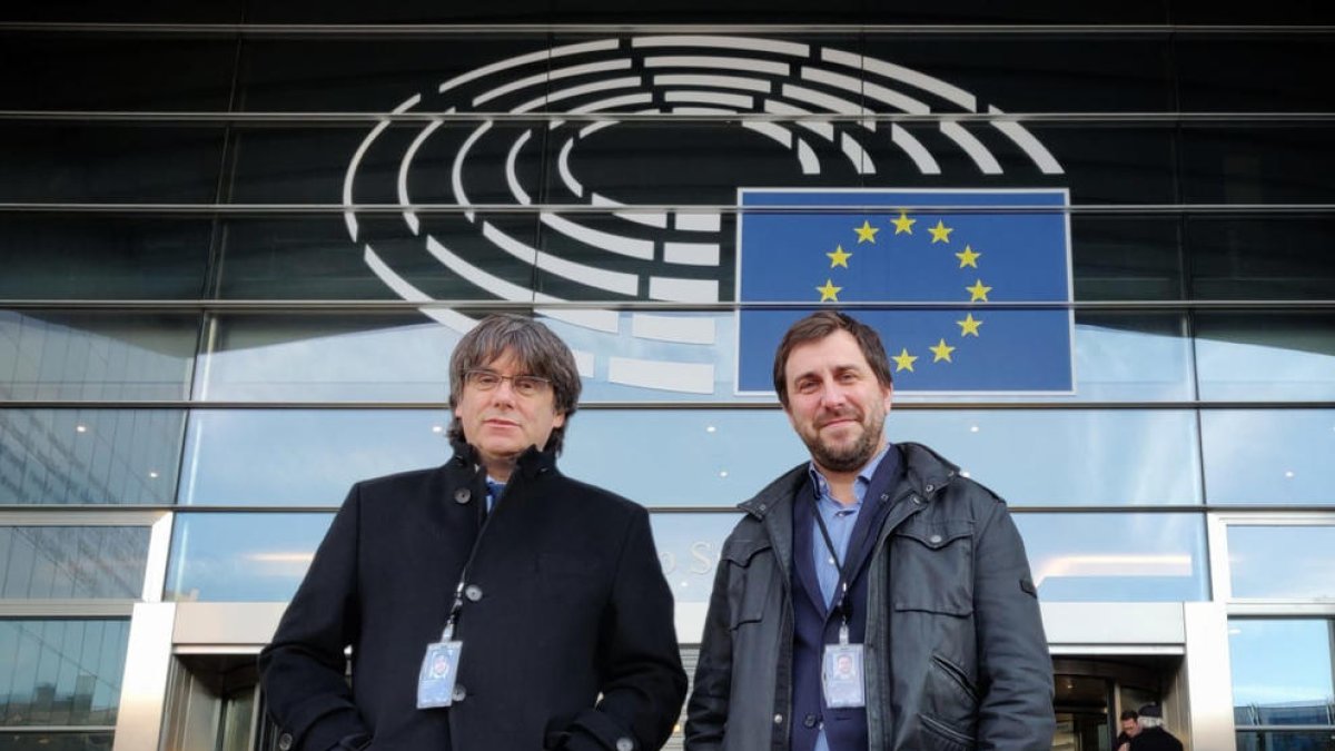 Carles Puigdemont y Toni Comín en la entrada del Parlamento europeo después de recoger las acreditaciones definitivas.