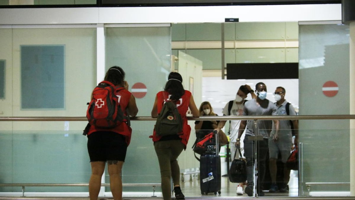 Turistes sortint de la zona d'arribades de la terminal 1 de l'aeroport de Barcelona-El Prat.