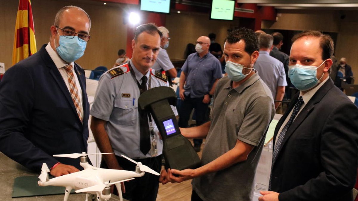 El conseller Miquel Buch, el director de los Mossos, Pere Ferrer, y el comisario jefe, Eduard Sallent, con un técnico que enseña un inhibidor de drones.