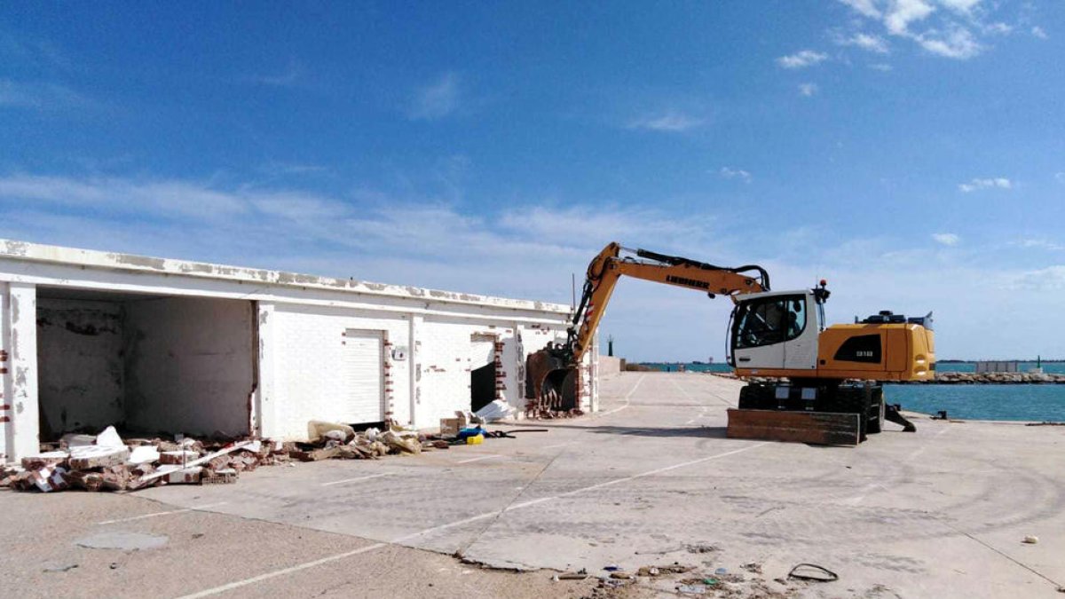 Una retroexcavadora derruint les casetes dels pescadors malmeses pels temporals.