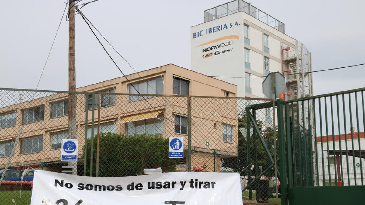 Exterior de l'empresa Bic Graphic a Tarragona, i d'un cartell penjat fora on s'hi llegeix que 'No som d'usar i tirar' i la xifra de '136' en referència als treballadors afectats per l'ERO, del 2 de maig del 2017