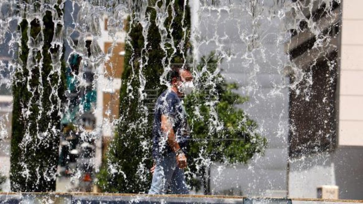 Un hombre camina este domingo por una fuente de Córdoba