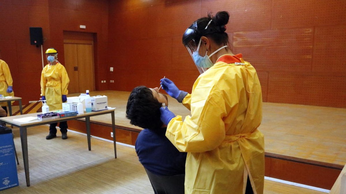 Un sanitario haciendo una prueba PCR a un vecino del barrio de Balàfia de Lérida