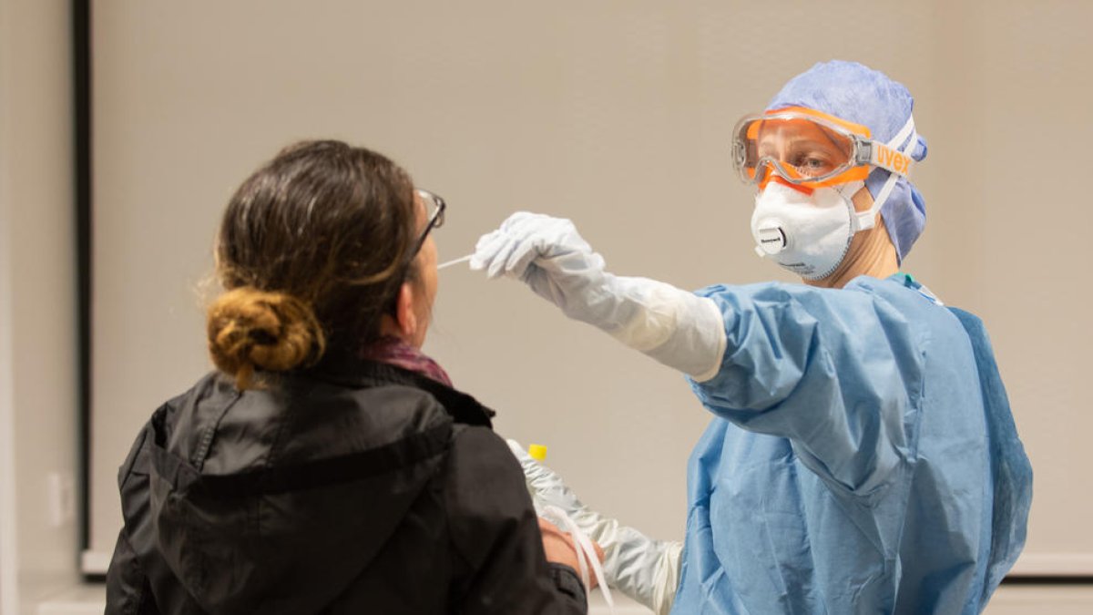 Una professional sanitària agafa una mostra per fer una prova de coronavirus a l'Hospital Clínic.