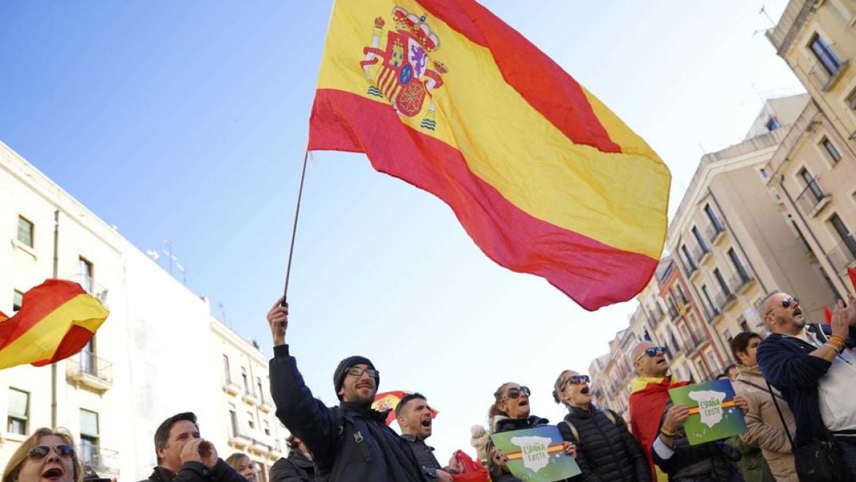 Un dels manifestants de la Plaça de la Font amb una bandera espanyola.