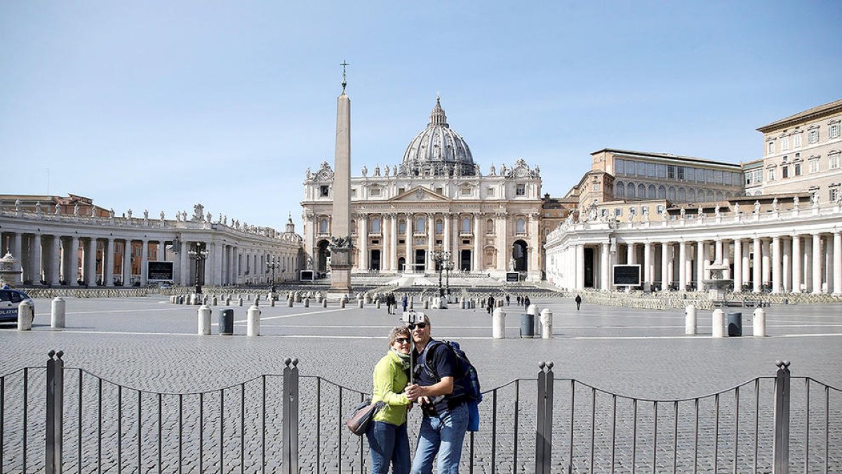 Imatge de turistes davant la plaça de Sant Pere, gairebé buida, a Roma.
