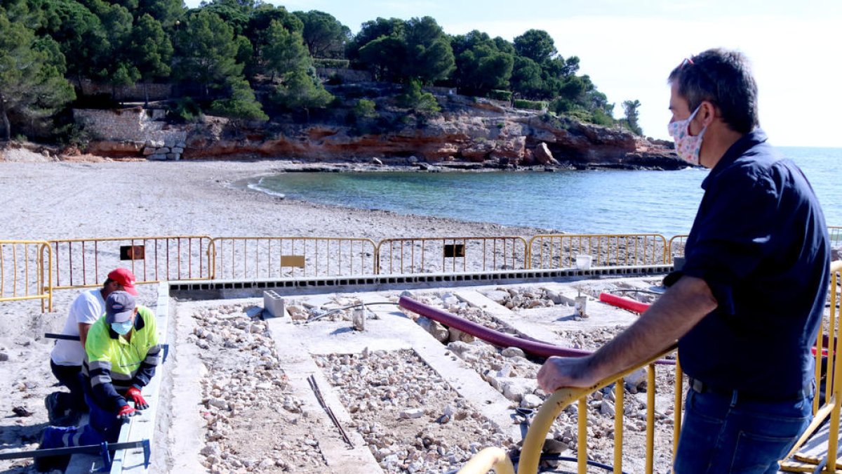 El alcalde de l'Ametlla de Mar, Jordi Gaseni, observando las obras de reconstrucción de la plataforma de duchas de la playa de Pixa-vaques.