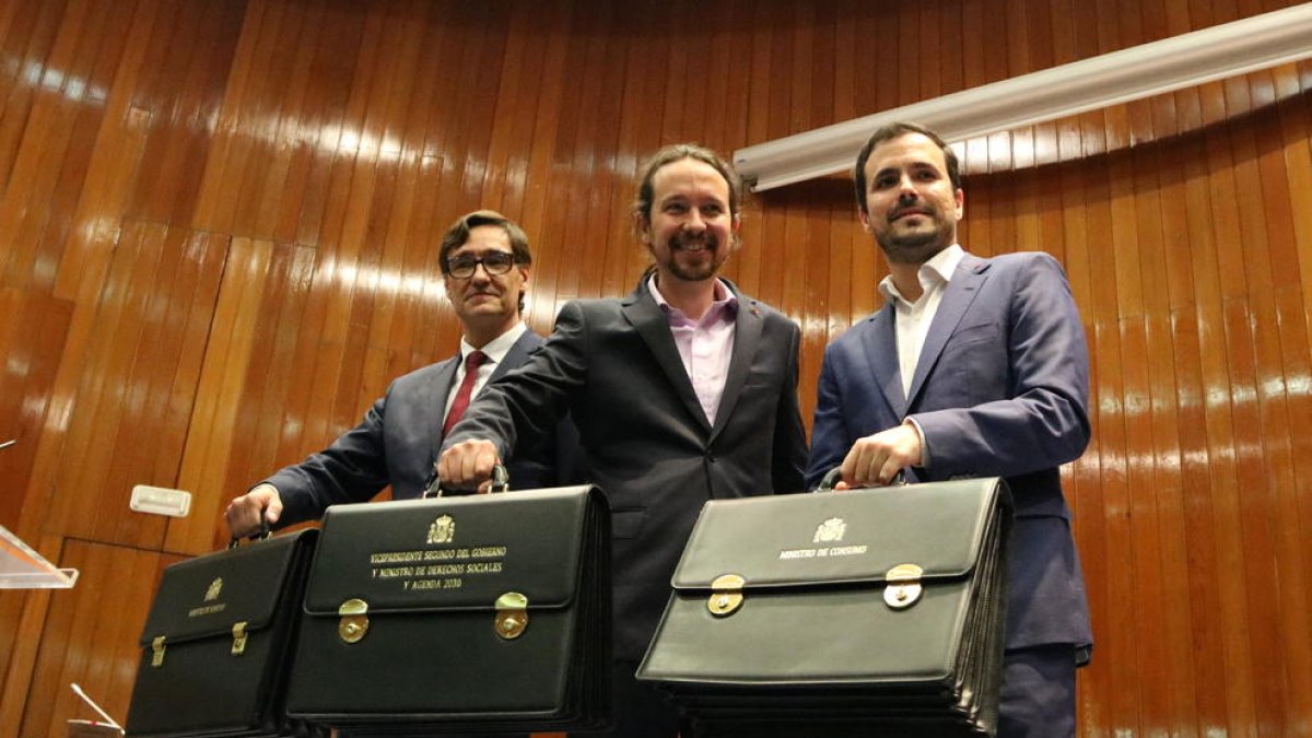 Ministro de Sanidad, Salvador Illa, el vicepresidente de Asuntos Sociales, Pablo Iglesias, y el ministro de Consumo, Alberto Garzón, con sus carteras de ministro.